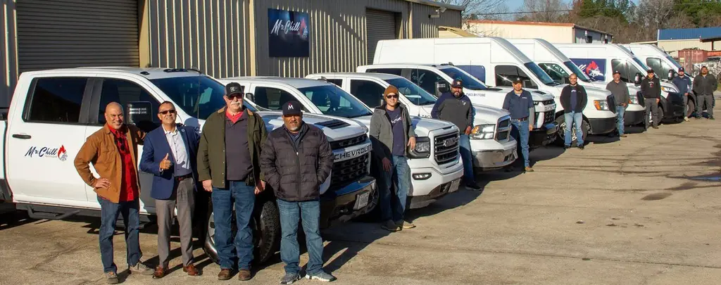 The Mr. Chill crew lined up in front of their branded trucks and vans, the Mr. Chill sign on the building behind them